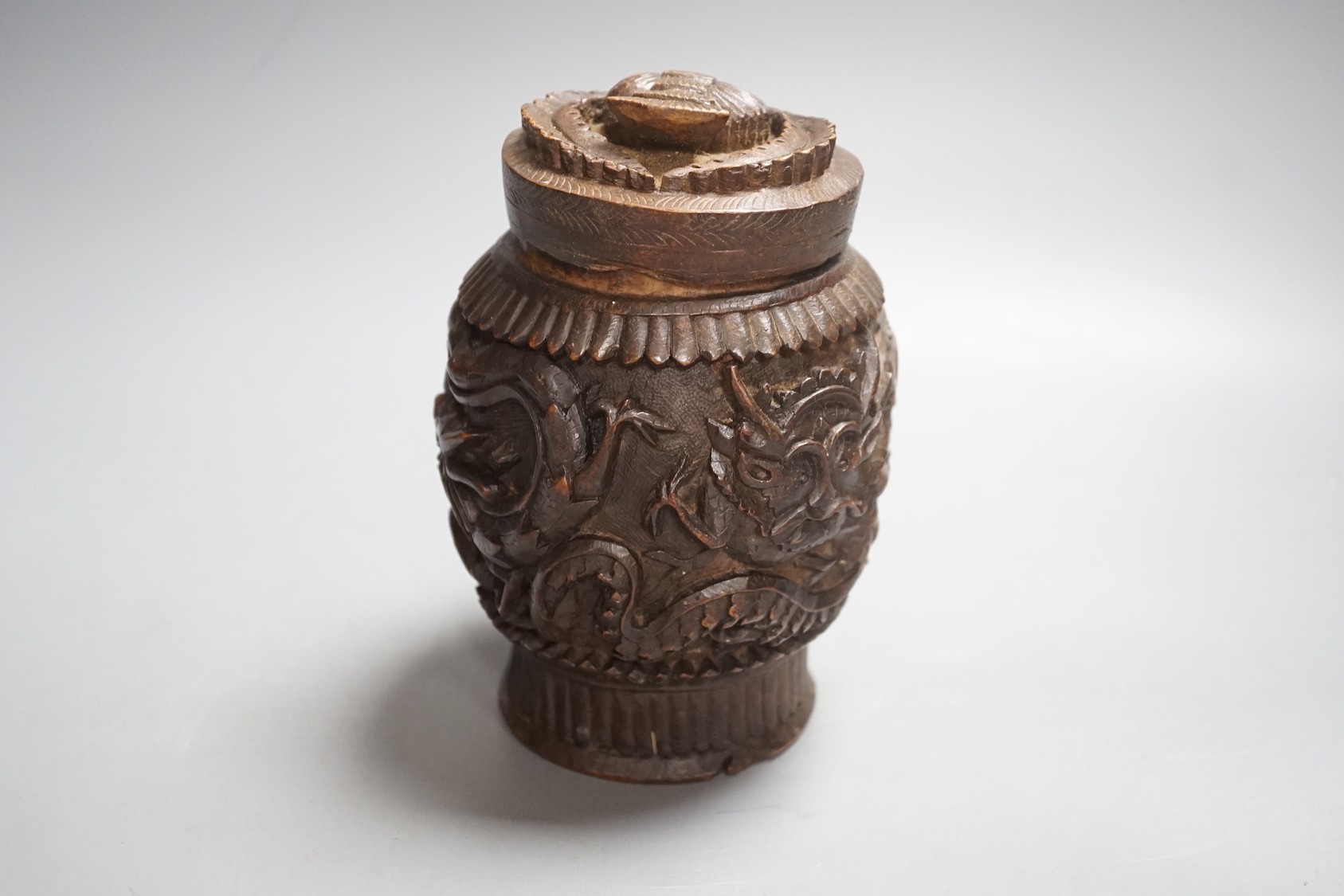 A Burmese carved wooden tobacco jar and cover - 17cm tall